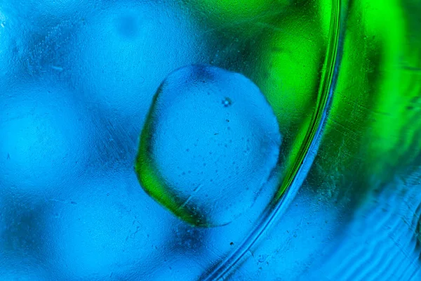 Su yüzeyinde yağ damlaları ve dalgaları olan soyut renkli arkaplan. Soyut arkaplan kavramı