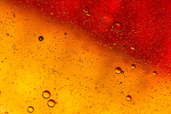 Su yüzeyinde yağ damlaları ve dalgaları olan soyut renkli arkaplan. Soyut arkaplan kavramı