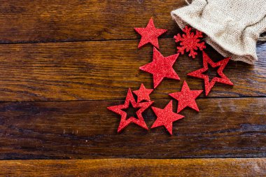 Noel çuvalı, parıltılı ve parlak Noel süslemeleri. Tahta üzerinde Noel süslemeleri. Kırmızı Noel yıldızları ve kar taneleri.