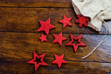 Noel çuvalı, parıltılı ve parlak Noel süslemeleri. Tahta üzerinde Noel süslemeleri. Kırmızı Noel yıldızları ve kar taneleri.