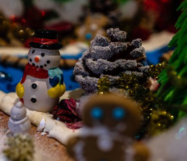 Arka planda bulanık bir Noel süsü var. Renkli seramik kardan adam heykeli.