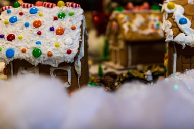 Renkli zencefilli kurabiye evi, bulanık arka planda, Noel süslemesiyle izole edilmiş..