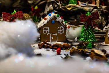 Renkli zencefilli kurabiye evi, bulanık arka planda, Noel süslemesiyle izole edilmiş..