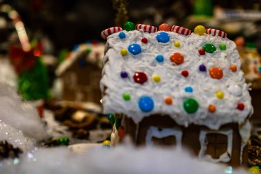 Renkli zencefilli kurabiye evi, bulanık arka planda, Noel süslemesiyle izole edilmiş..