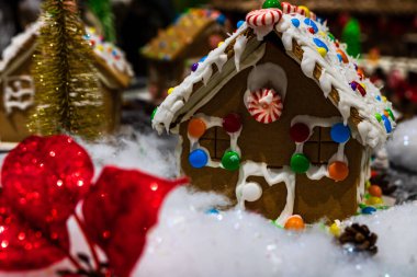 Renkli zencefilli kurabiye evi, bulanık arka planda, Noel süslemesiyle izole edilmiş..
