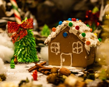 Arka planda bulanık bir Noel süsü var. Şekerli zencefilli evler.