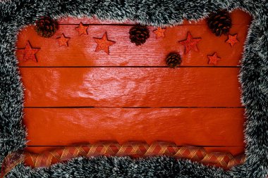 Noel çelengi ve süslemeleri olan kırmızı tahta üzerinde Noel kompozisyonu. Sınır ve kopyalama alanı ile yaratıcı kompozisyon, üst görünüm, düz yatay. Noel çerçevesi.