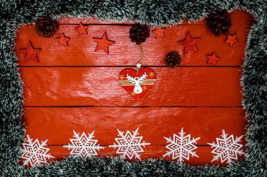Noel çelengi ve süslemeleri olan kırmızı tahta üzerinde Noel kompozisyonu. Sınır ve kopyalama alanı ile yaratıcı kompozisyon, üst görünüm, düz yatay. Noel çerçevesi.