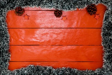Noel çelengi ve süslemeleri olan kırmızı tahta üzerinde Noel kompozisyonu. Sınır ve kopyalama alanı ile yaratıcı kompozisyon, üst görünüm, düz yatay. Noel çerçevesi.