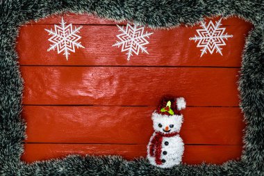 Noel çelengi ve süslemeleri olan kırmızı tahta üzerinde Noel kompozisyonu. Sınır ve kopyalama alanı ile yaratıcı kompozisyon, üst görünüm, düz yatay. Noel çerçevesi.