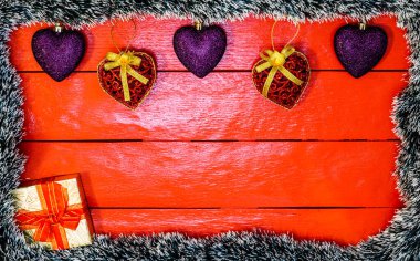 Noel çelengi ve süslemeleri olan kırmızı tahta üzerinde Noel kompozisyonu. Sınır ve kopyalama alanı ile yaratıcı kompozisyon, üst görünüm, düz yatay. Noel çerçevesi.