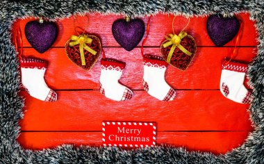 Noel çelengi ve süslemeleri olan kırmızı tahta üzerinde Noel kompozisyonu. Sınır ve kopyalama alanı ile yaratıcı kompozisyon, üst görünüm, düz yatay. Noel çerçevesi.