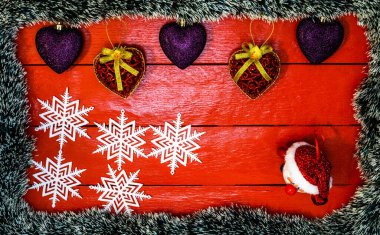 Noel çelengi ve süslemeleri olan kırmızı tahta üzerinde Noel kompozisyonu. Sınır ve kopyalama alanı ile yaratıcı kompozisyon, üst görünüm, düz yatay. Noel çerçevesi.