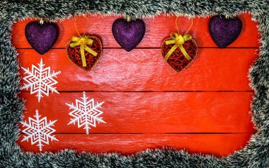 Noel çelengi ve süslemeleri olan kırmızı tahta üzerinde Noel kompozisyonu. Sınır ve kopyalama alanı ile yaratıcı kompozisyon, üst görünüm, düz yatay. Noel çerçevesi.
