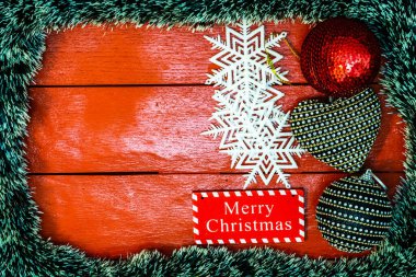 Noel çelengi ve süslemeleri olan kırmızı tahta üzerinde Noel kompozisyonu. Sınır ve kopyalama alanı ile yaratıcı kompozisyon, üst görünüm, düz yatay. Noel çerçevesi.