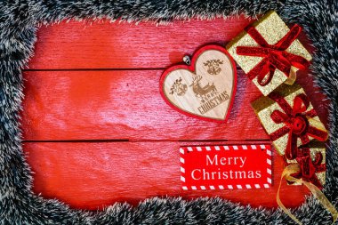 Noel çelengi ve süslemeleri olan kırmızı tahta üzerinde Noel kompozisyonu. Sınır ve kopyalama alanı ile yaratıcı kompozisyon, üst görünüm, düz yatay. Noel çerçevesi.