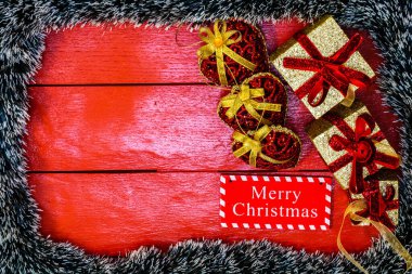 Noel çelengi ve süslemeleri olan kırmızı tahta üzerinde Noel kompozisyonu. Sınır ve kopyalama alanı ile yaratıcı kompozisyon, üst görünüm, düz yatay. Noel çerçevesi.
