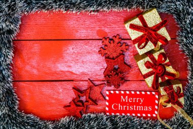 Noel çelengi ve süslemeleri olan kırmızı tahta üzerinde Noel kompozisyonu. Sınır ve kopyalama alanı ile yaratıcı kompozisyon, üst görünüm, düz yatay. Noel çerçevesi.