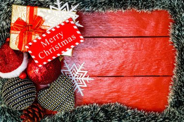 Noel çelengi ve süslemeleri olan kırmızı tahta üzerinde Noel kompozisyonu. Sınır ve kopyalama alanı ile yaratıcı kompozisyon, üst görünüm, düz yatay. Noel çerçevesi.
