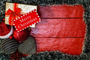 Noel çelengi ve süslemeleri olan kırmızı tahta üzerinde Noel kompozisyonu. Sınır ve kopyalama alanı ile yaratıcı kompozisyon, üst görünüm, düz yatay. Noel çerçevesi.