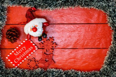 Noel çelengi ve süslemeleri olan kırmızı tahta üzerinde Noel kompozisyonu. Sınır ve kopyalama alanı ile yaratıcı kompozisyon, üst görünüm, düz yatay. Noel çerçevesi.