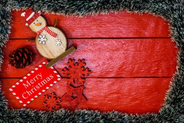 Noel çelengi ve süslemeleri olan kırmızı tahta üzerinde Noel kompozisyonu. Sınır ve kopyalama alanı ile yaratıcı kompozisyon, üst görünüm, düz yatay. Noel çerçevesi.