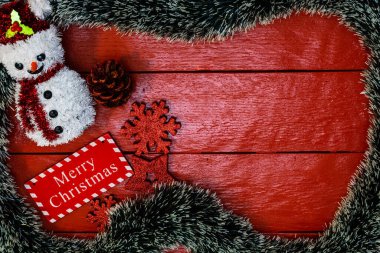 Noel çelengi ve süslemeleri olan kırmızı tahta üzerinde Noel kompozisyonu. Sınır ve kopyalama alanı ile yaratıcı kompozisyon, üst görünüm, düz yatay. Noel çerçevesi.
