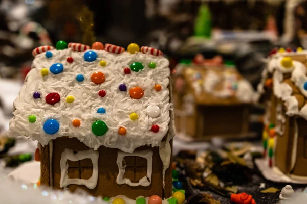 Arka planda bulanık bir Noel süsü var. Şekerli zencefilli evler.
