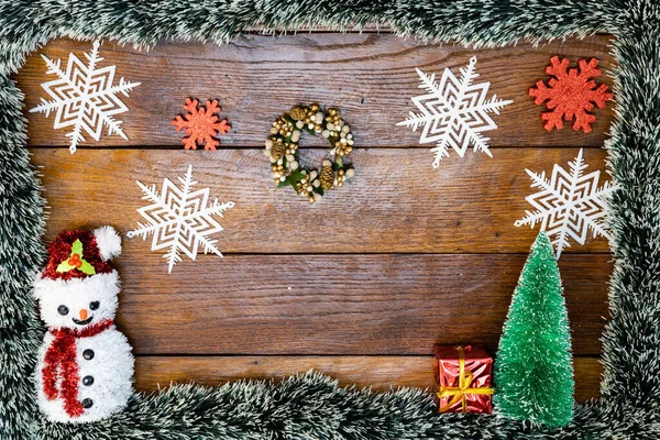 Tahtada Noel çelengi ve süslemeleri olan bir Noel kompozisyonu. Sınır ve kopyalama alanı ile yaratıcı kompozisyon, üst görünüm, düz yatay. Noel çerçevesi.