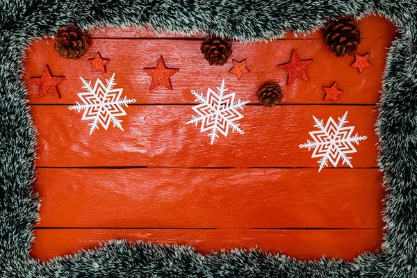 クリスマスのガーランドと装飾と赤い木製のボード上のクリスマスの組成 境界線とコピースペース トップビュー フラットレイアウトと創造的な組成 クリスマス フレーム — ストック写真