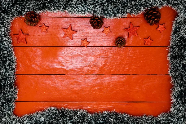 Noel çelengi ve süslemeleri olan kırmızı tahta üzerinde Noel kompozisyonu. Sınır ve kopyalama alanı ile yaratıcı kompozisyon, üst görünüm, düz yatay. Noel çerçevesi.