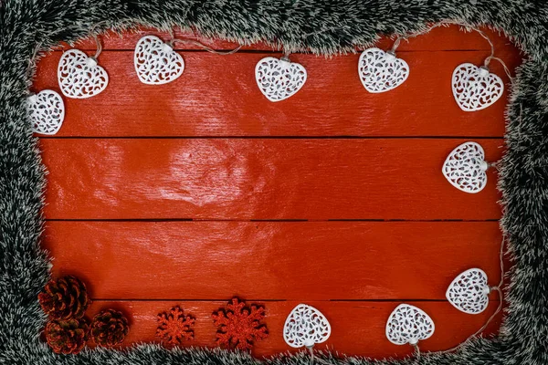 Noel çelengi ve süslemeleri olan kırmızı tahta üzerinde Noel kompozisyonu. Sınır ve kopyalama alanı ile yaratıcı kompozisyon, üst görünüm, düz yatay. Noel çerçevesi.