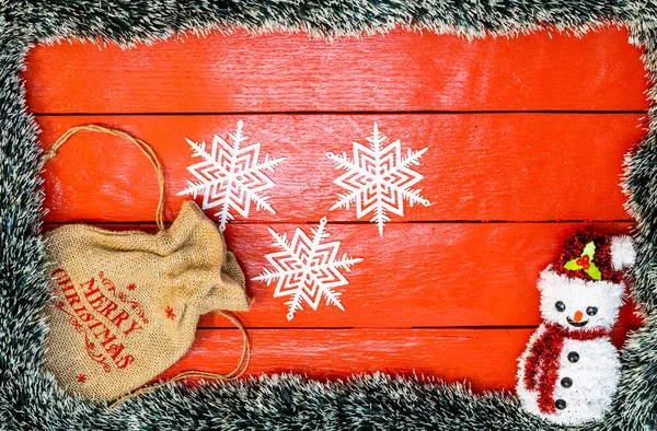 Noel çelengi ve süslemeleri olan kırmızı tahta üzerinde Noel kompozisyonu. Sınır ve kopyalama alanı ile yaratıcı kompozisyon, üst görünüm, düz yatay. Noel çerçevesi.