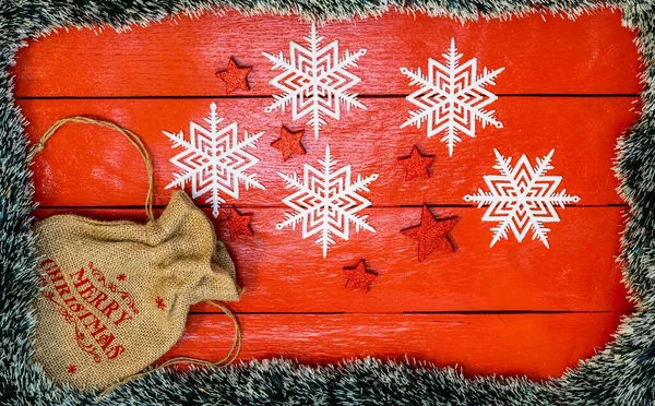 Noel çelengi ve süslemeleri olan kırmızı tahta üzerinde Noel kompozisyonu. Sınır ve kopyalama alanı ile yaratıcı kompozisyon, üst görünüm, düz yatay. Noel çerçevesi.