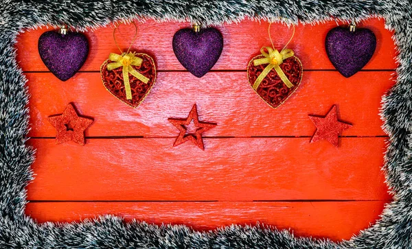 Noel çelengi ve süslemeleri olan kırmızı tahta üzerinde Noel kompozisyonu. Sınır ve kopyalama alanı ile yaratıcı kompozisyon, üst görünüm, düz yatay. Noel çerçevesi.