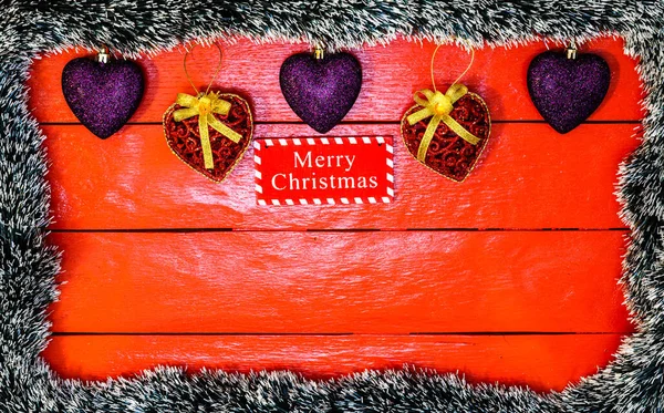 Noel çelengi ve süslemeleri olan kırmızı tahta üzerinde Noel kompozisyonu. Sınır ve kopyalama alanı ile yaratıcı kompozisyon, üst görünüm, düz yatay. Noel çerçevesi.