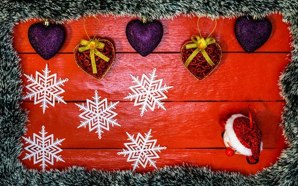 Noel çelengi ve süslemeleri olan kırmızı tahta üzerinde Noel kompozisyonu. Sınır ve kopyalama alanı ile yaratıcı kompozisyon, üst görünüm, düz yatay. Noel çerçevesi.