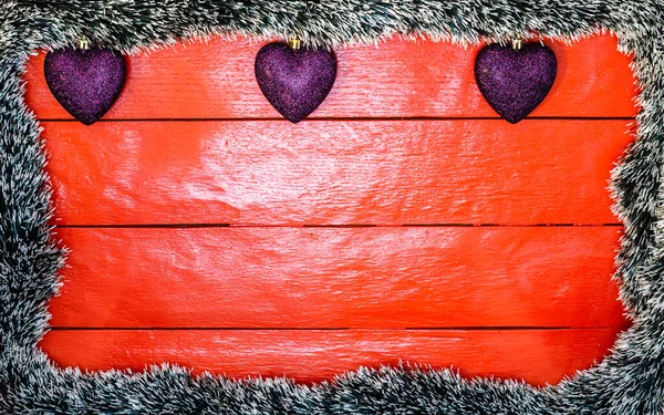 Noel çelengi ve süslemeleri olan kırmızı tahta üzerinde Noel kompozisyonu. Sınır ve kopyalama alanı ile yaratıcı kompozisyon, üst görünüm, düz yatay. Noel çerçevesi.