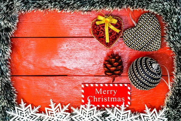Noel çelengi ve süslemeleri olan kırmızı tahta üzerinde Noel kompozisyonu. Sınır ve kopyalama alanı ile yaratıcı kompozisyon, üst görünüm, düz yatay. Noel çerçevesi.