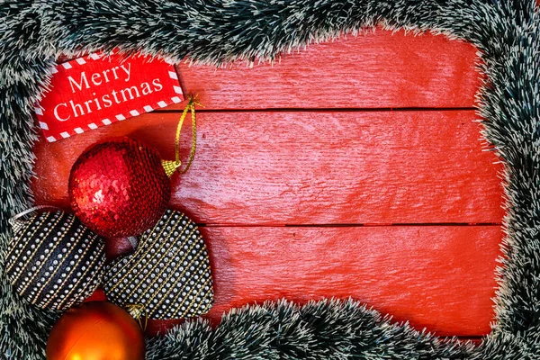 Noel çelengi ve süslemeleri olan kırmızı tahta üzerinde Noel kompozisyonu. Sınır ve kopyalama alanı ile yaratıcı kompozisyon, üst görünüm, düz yatay. Noel çerçevesi.