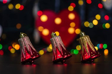 Noel süsü ve süsleri. Bulanık ışık arkaplanındaki Noel kompozisyonu. Neşeli Noel çanları.