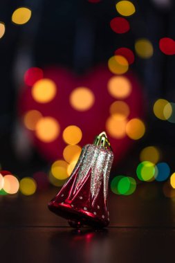 Noel süsü ve süsleri. Bulanık ışık arkaplanındaki Noel kompozisyonu. Neşeli Noel çanları.