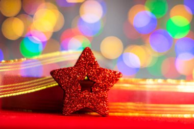 Renkli bir Noel kompozisyonu olan kırmızı parıltılı süslemeler bulanık ışıkların arka planında izole edilmiş..