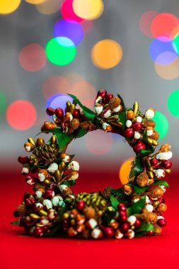 Bulanık ışıkların arka planında izole edilmiş renkli Noel çelenkleri.