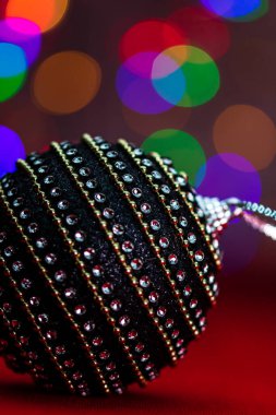 Siyah ve parlak bir Noel balosu. Bulanık ışıkların arka planında bir Noel kompozisyonu..