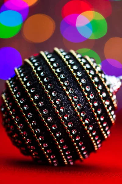 Siyah ve parlak bir Noel balosu. Bulanık ışıkların arka planında bir Noel kompozisyonu..