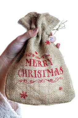 El ele tutuşan Noel çuvalı beyaz arka planda izole edilmiş