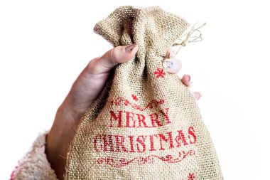 El ele tutuşan Noel çuvalı beyaz arka planda izole edilmiş