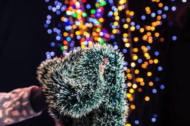 Arka planda bulanık ışıklarla izole edilmiş Noel çelenkleri duruyor. Aralık sezonu, Noel kompozisyonu.
