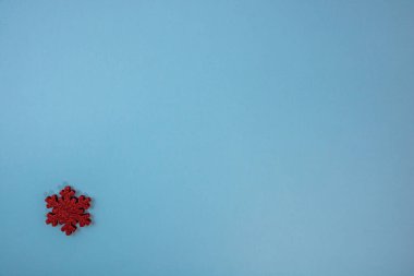 Kırmızı parıltılı kar tanesi süslemeli mavi Noel arkaplanı. Noel kompozisyonunu kopyalamak için üst görünüm.